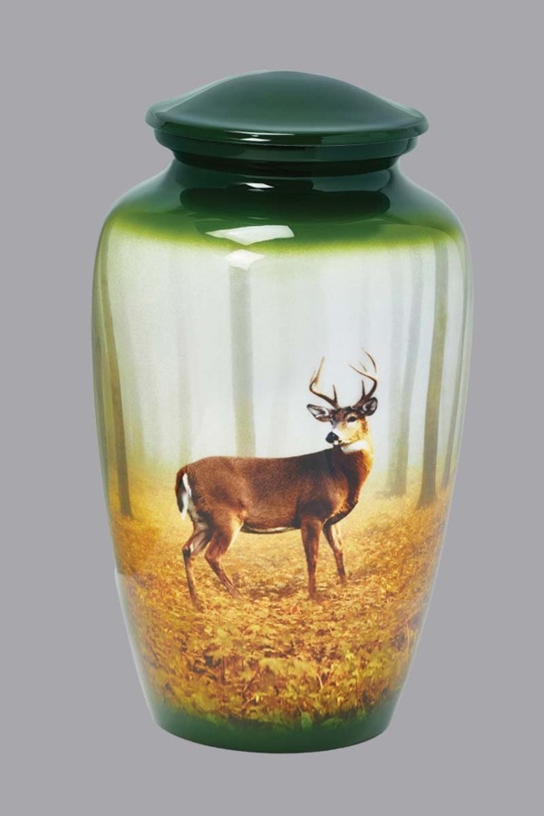 Single Deer stands in the forest on rich green urn
